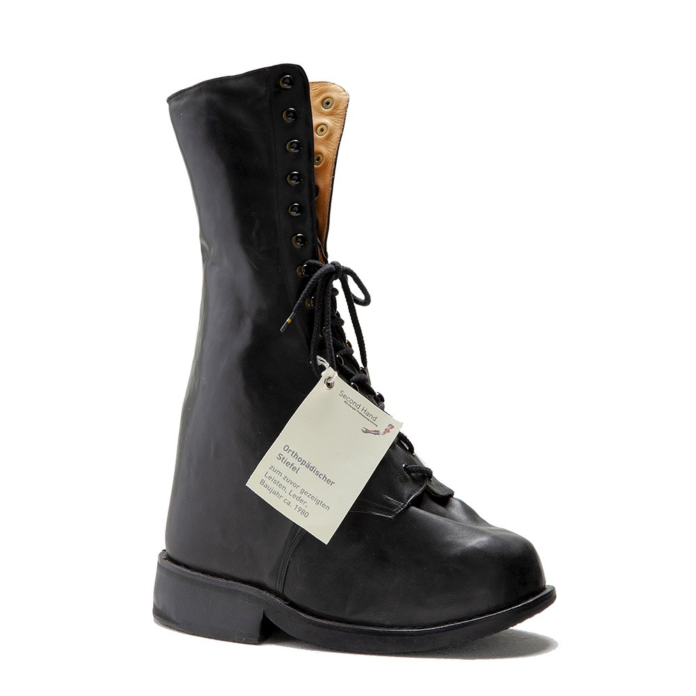 Ein orthopädischer Stiefel aus schwarzem Leder mit hohem Schaft und extremen Proportionen