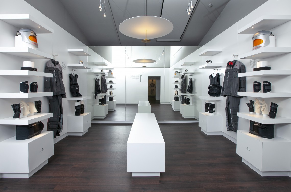 Blick in den stylischen Ankleideraum mit zwei AgeMan Alterssimulationsanzügen die wie in einem edlen Designer-Shop präsentiert sind