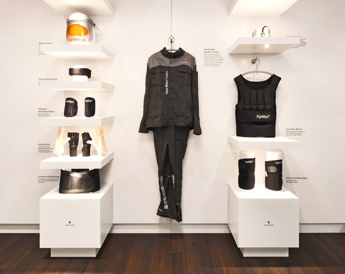 Detailansicht der stylischen Präsentation eines AgeMan Alterssimulationsanzugs und seiner einzelnen Komponenten