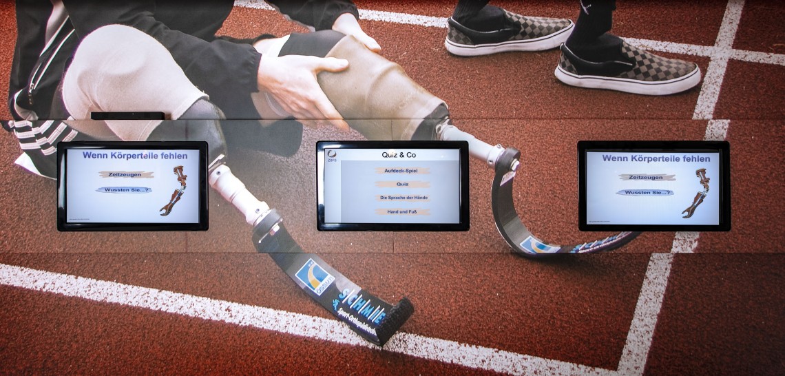 Detailansicht von drei wandmontierten Touchscreen-Monitoren in der Ausstellung